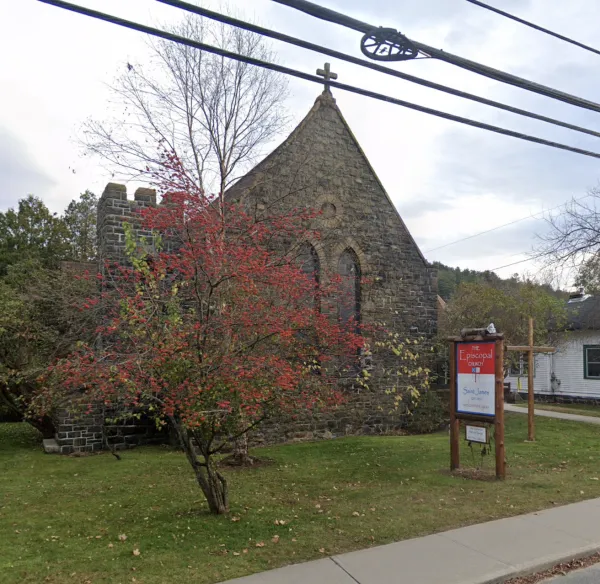 An old stone church with a flowering tree